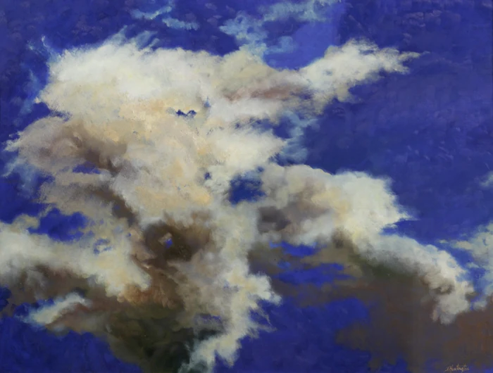 White and gray clouds gather against a deep cobalt-blue sky.